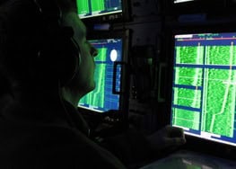 Network monitoring with multiple screens displaying data and cybersecurity analysis.