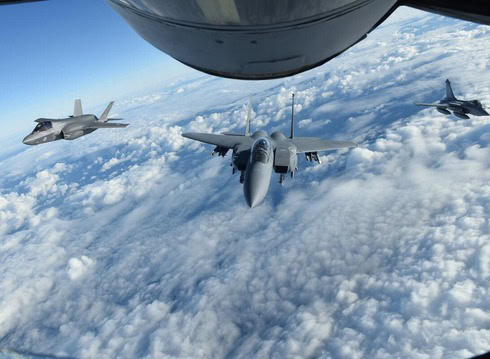 Fighter jets flying in formation above the clouds during a high-altitude mission.