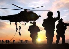 Military helicopter with soldiers during sunset, preparing for deployment.