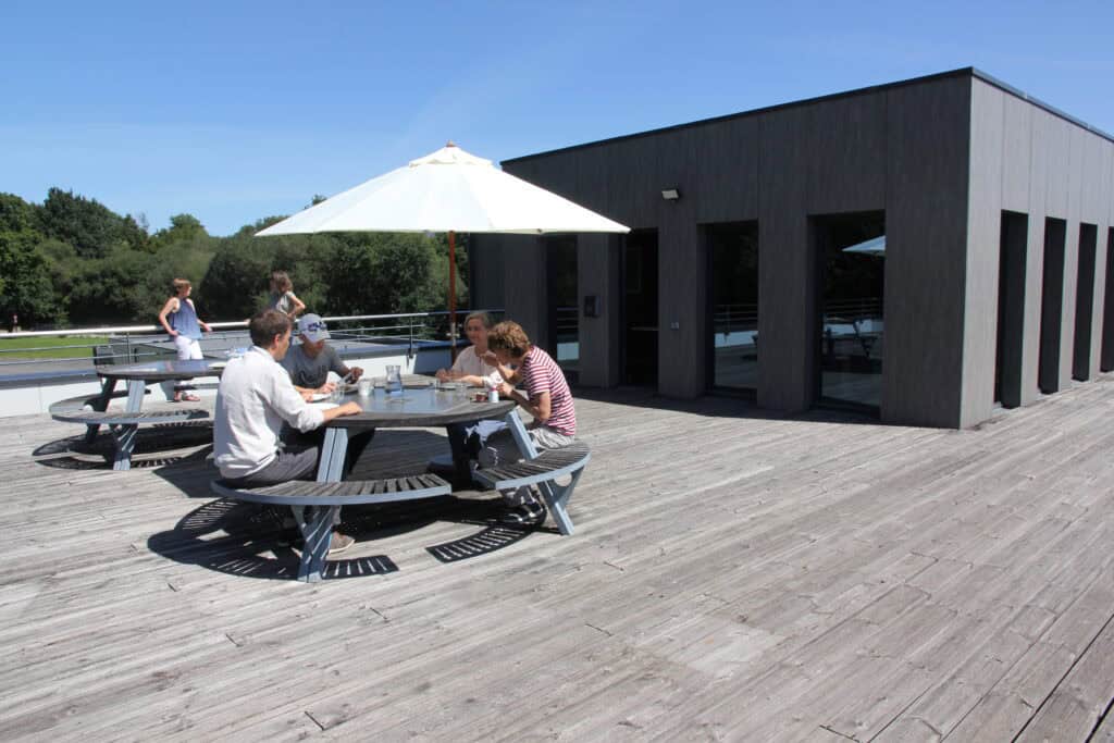 Outdoor terrace with picnic tables and umbrella at Interface Concept.
