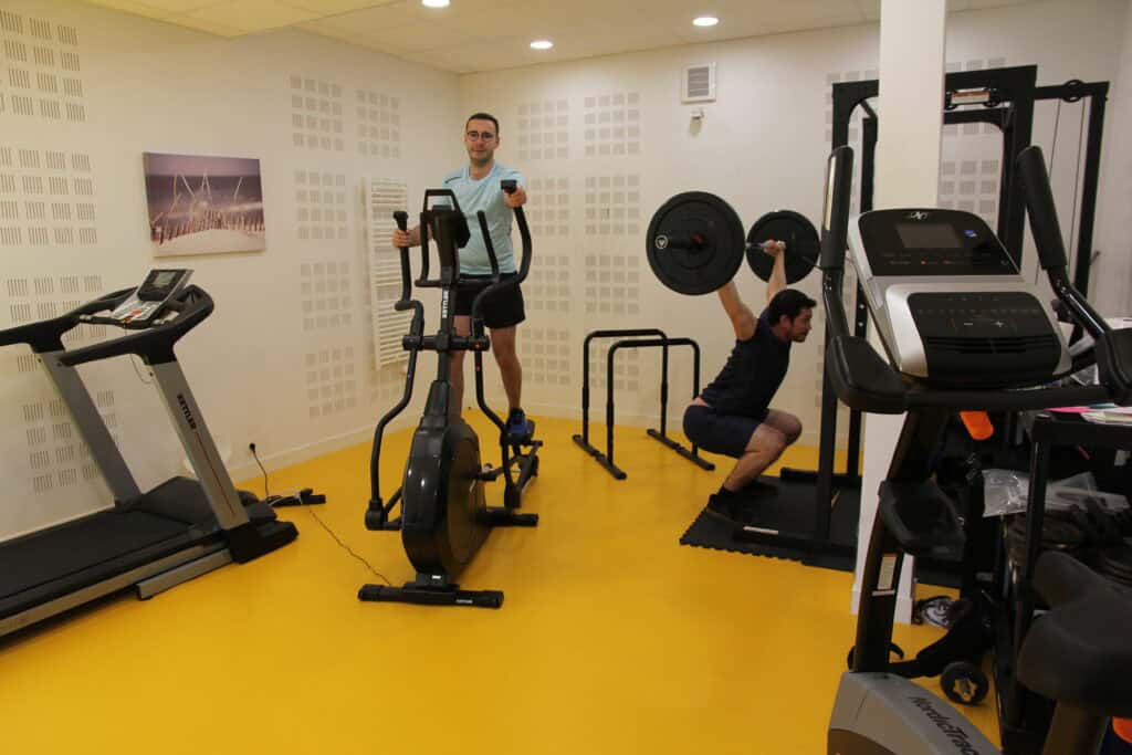 Gym with cardio machines and weight training equipment for fitness enthusiasts.